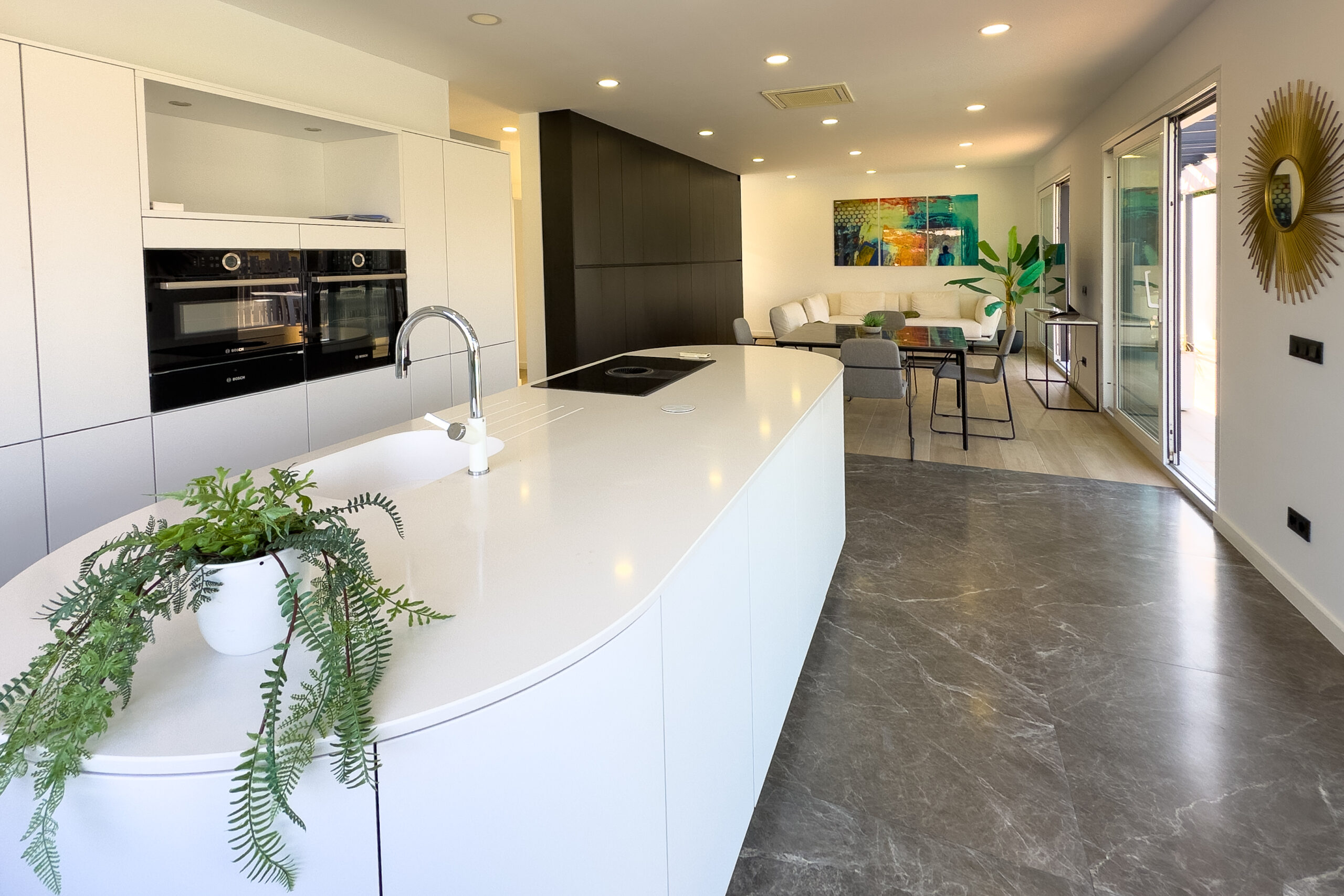 Open plan kitchen with island and built-in appliances in a modern Calpe villa