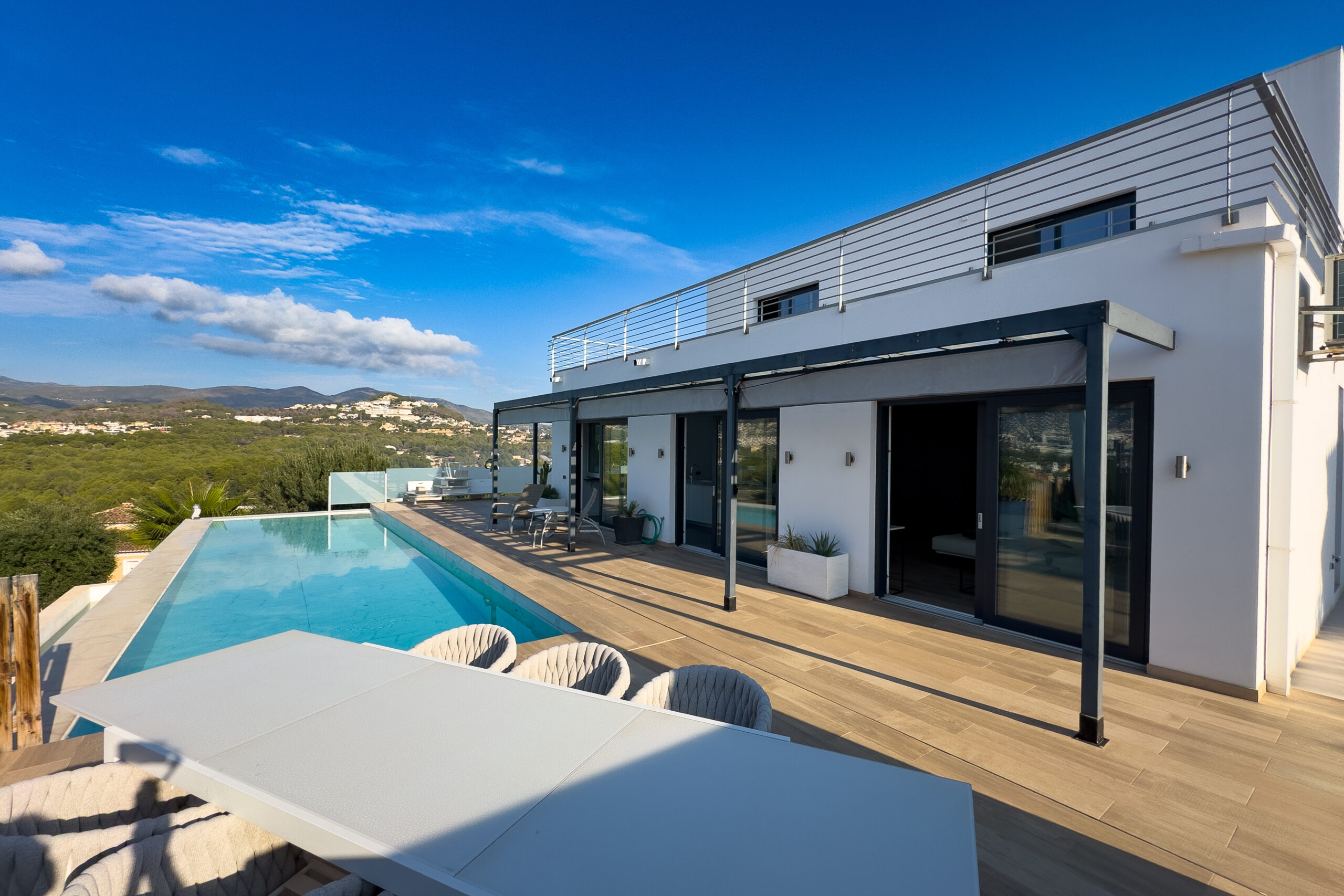 Outdoor terrace dining area beside the pool at a modern villa in Calpe
