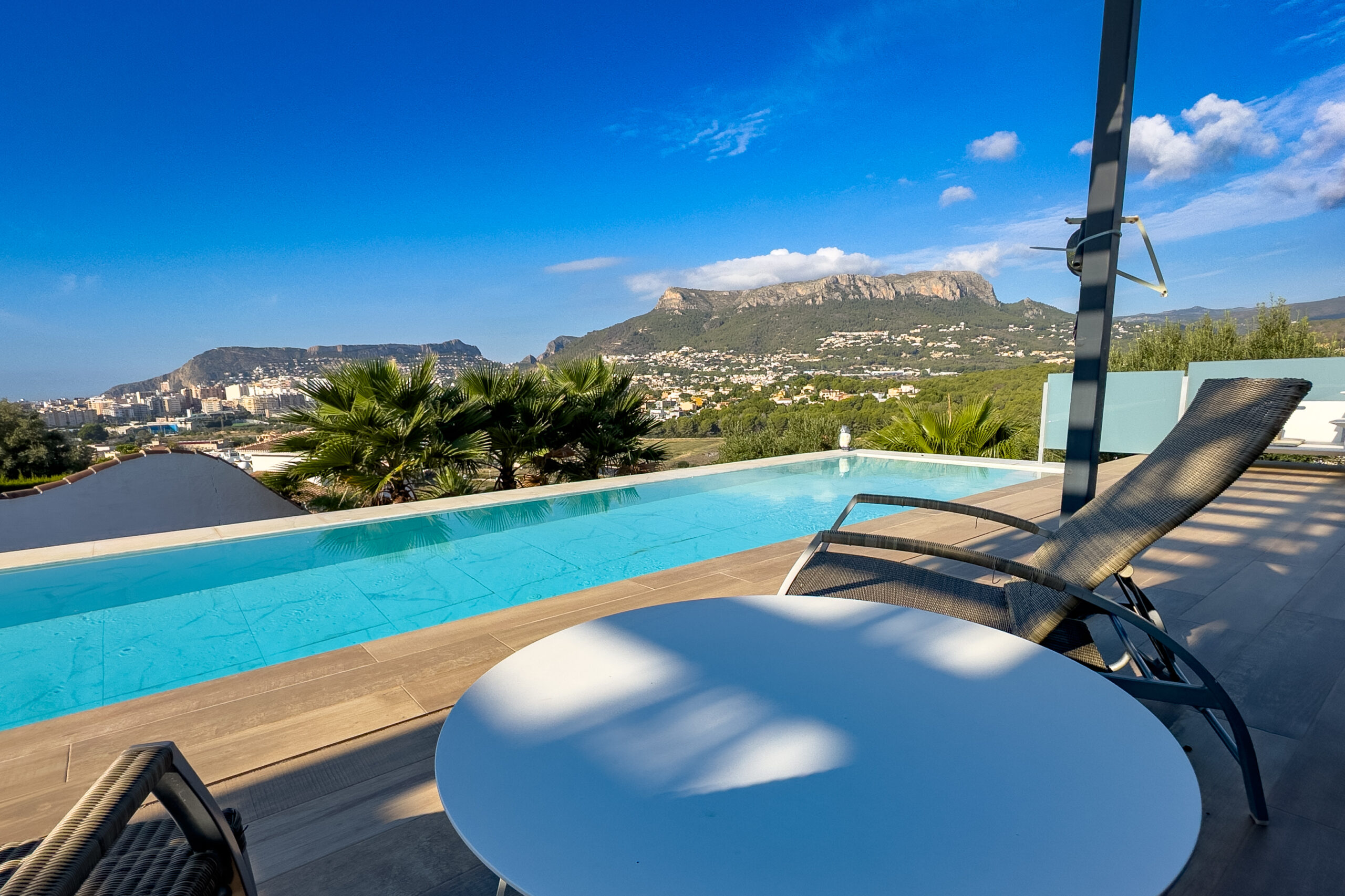 Poolside loungers with open mountain views at a villa in Casanova, Calpe