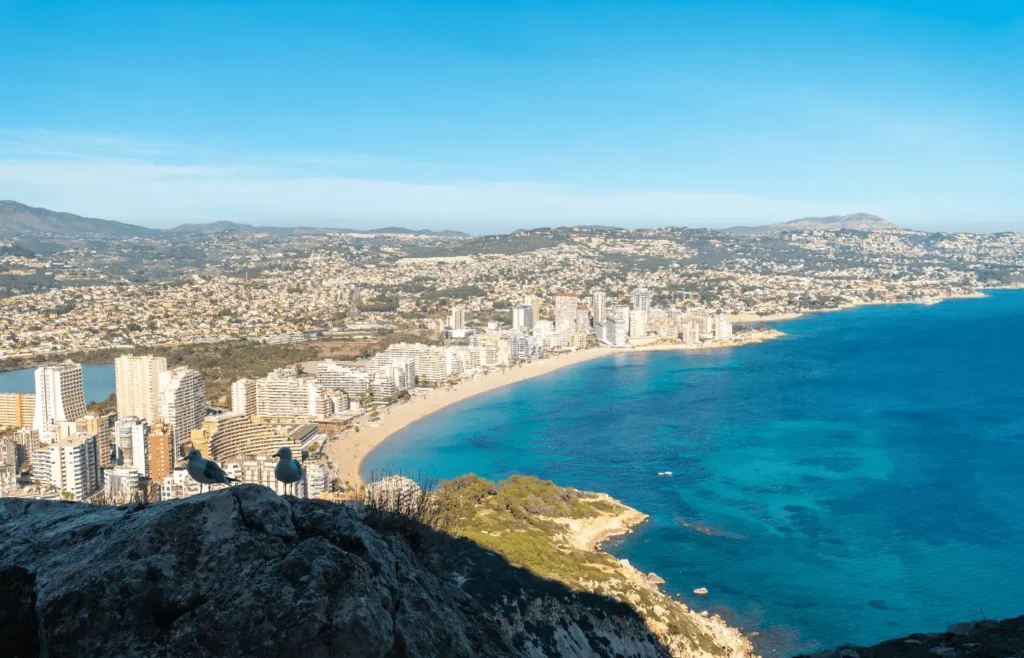 Panoramic view of La Fossa in Calpe showing the curved beach, apartment buildings, and seafront