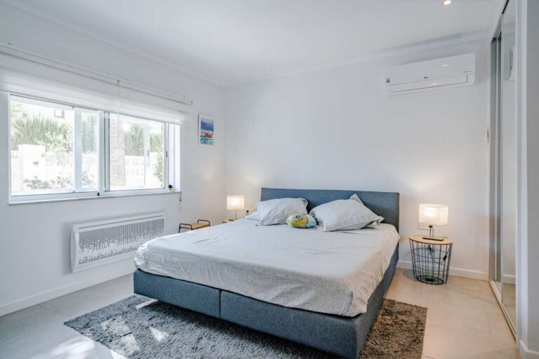 Double bedroom inside a modern villa in Calpe with large window, air conditioning and natural light