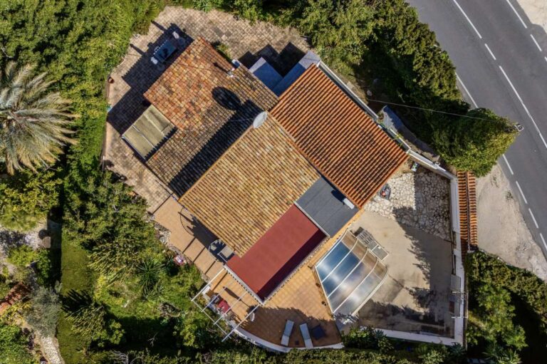 Aerial view of a Mediterranean villa in Benissa Costa near Cala Baladrar with covered swimming pool, terraces and mature garden
