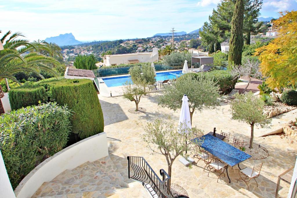 Garden terrace with pool and views towards the Peñón de Ifach at Moraira villa