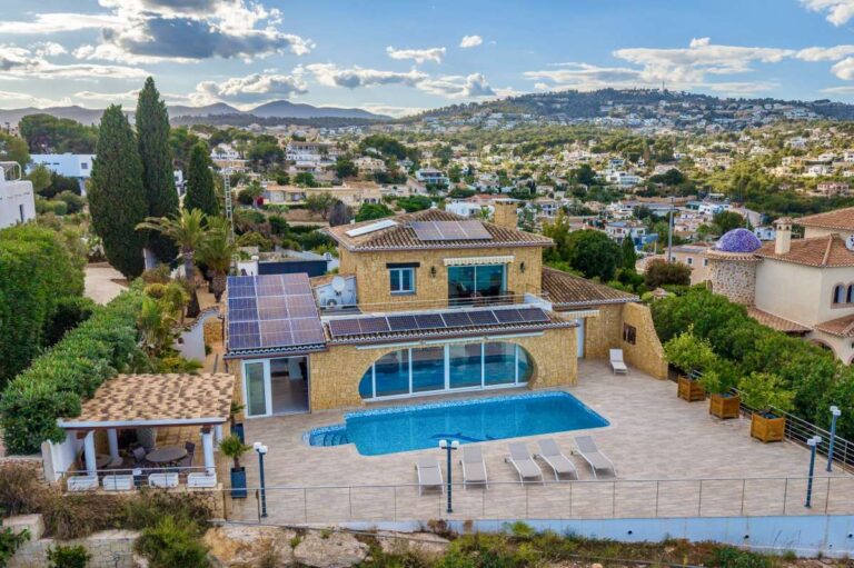 Aerial view of a Benissa Costa villa with private swimming pool, large sea-view terrace, sun loungers and surrounding residential area