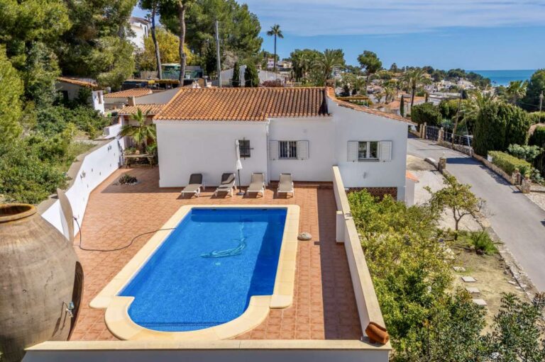 Aerial view of a charming Benissa Coast villa with private swimming pool, sun terrace, red-tiled roof and sea views in the distance