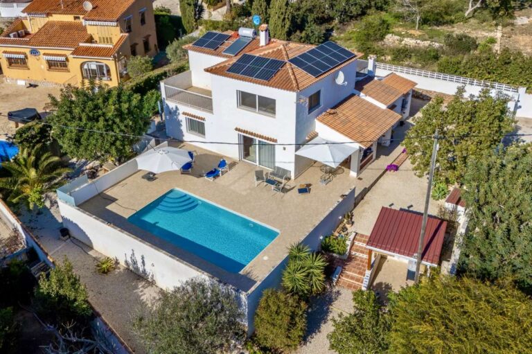 Aerial view of a contemporary villa in Calpe with private swimming pool, terrace, garden area and solar panels.