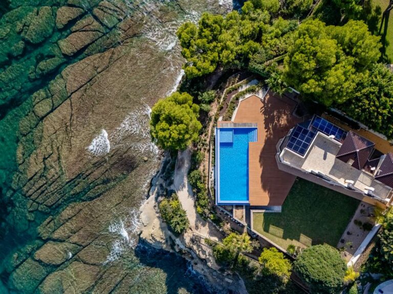 Aerial view of a frontline villa plot with private pool and direct coastal position in Les Bassetes.
