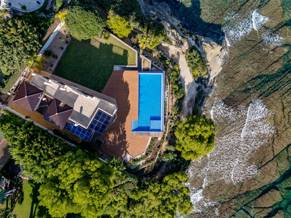Aerial view of a frontline villa plot with private pool and direct coastal position in Les Bassetes, Benissa Coast.