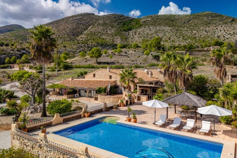 Aerial view of a historic luxury finca in Benissa with private pool, sun terrace, parasols and mountain views