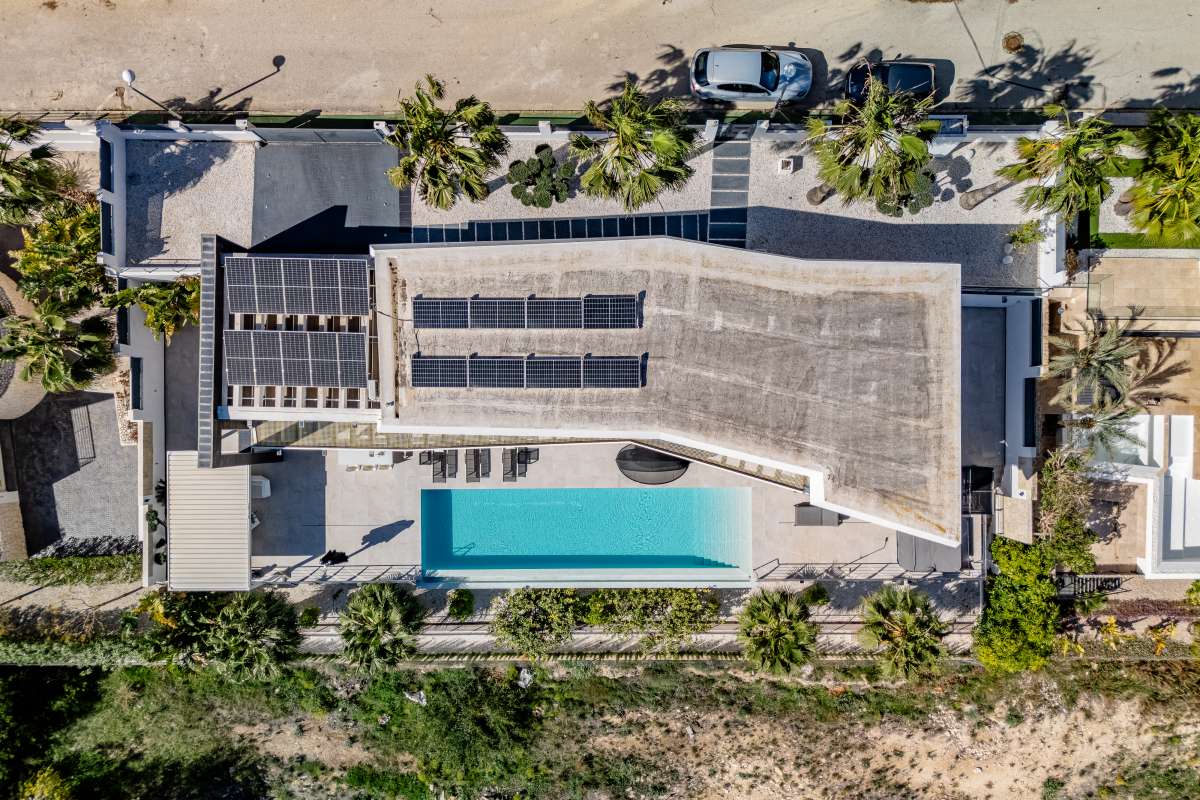 Aerial view of a luxury modern villa in Gran Sol, Calpe with infinity pool, photovoltaic panels and landscaped garden.