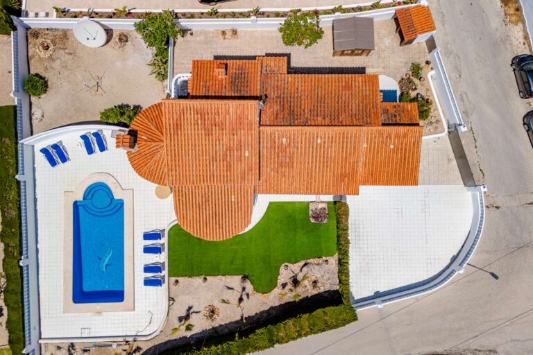 Aerial view of a Mediterranean villa in Calpe with private pool, terrace, garden area and parking.