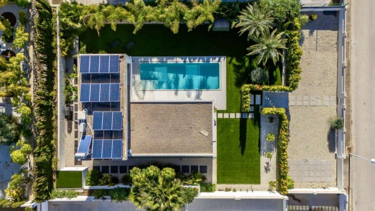 Aerial view of a modern oasis villa in Calpe with private pool, garden, terrace and solar panels.