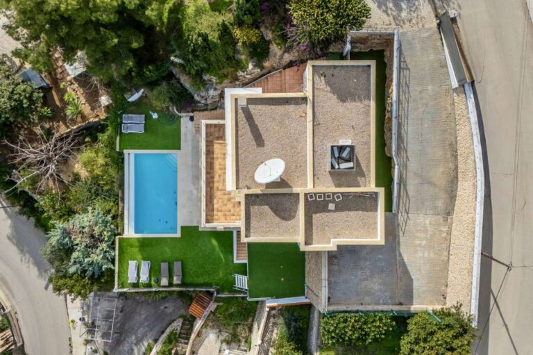 Aerial view of a modern spacious villa in Calpe with private pool, garden area and surrounding plot.