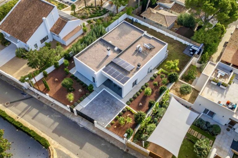 Aerial view of a single-level modern villa in Santa Clara, Altea with flat plot, solar panels, landscaped garden and private parking area