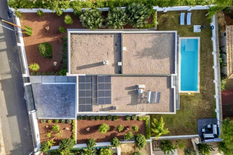 Aerial view of a single-level modern villa in Santa Clara, Altea with solar panels, saltwater pool, flat plot, landscaped garden and private parking