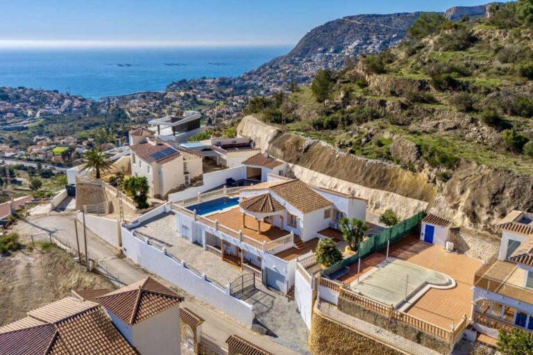 Aerial view of a villa in Calpe with sea views, terraces, private pool, and mountain surroundings.
