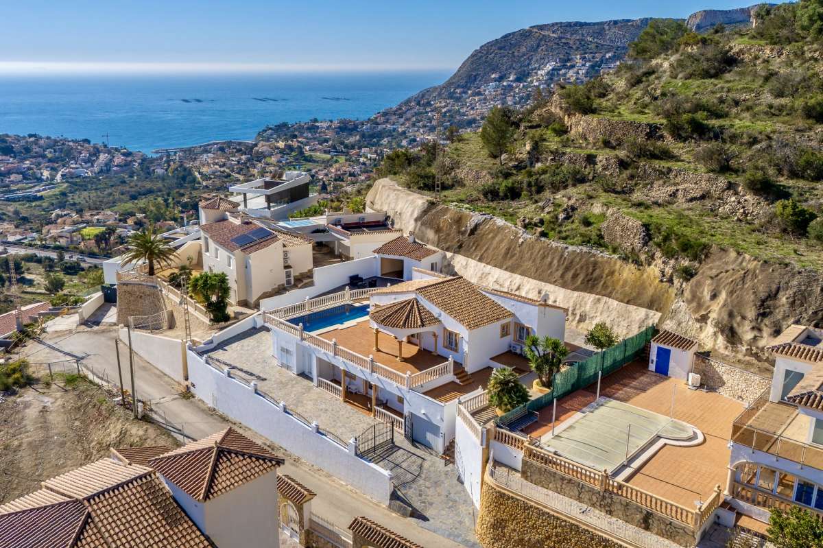 Aerial view of a villa in Calpe with sea views, terraces, private pool, and mountain surroundings.