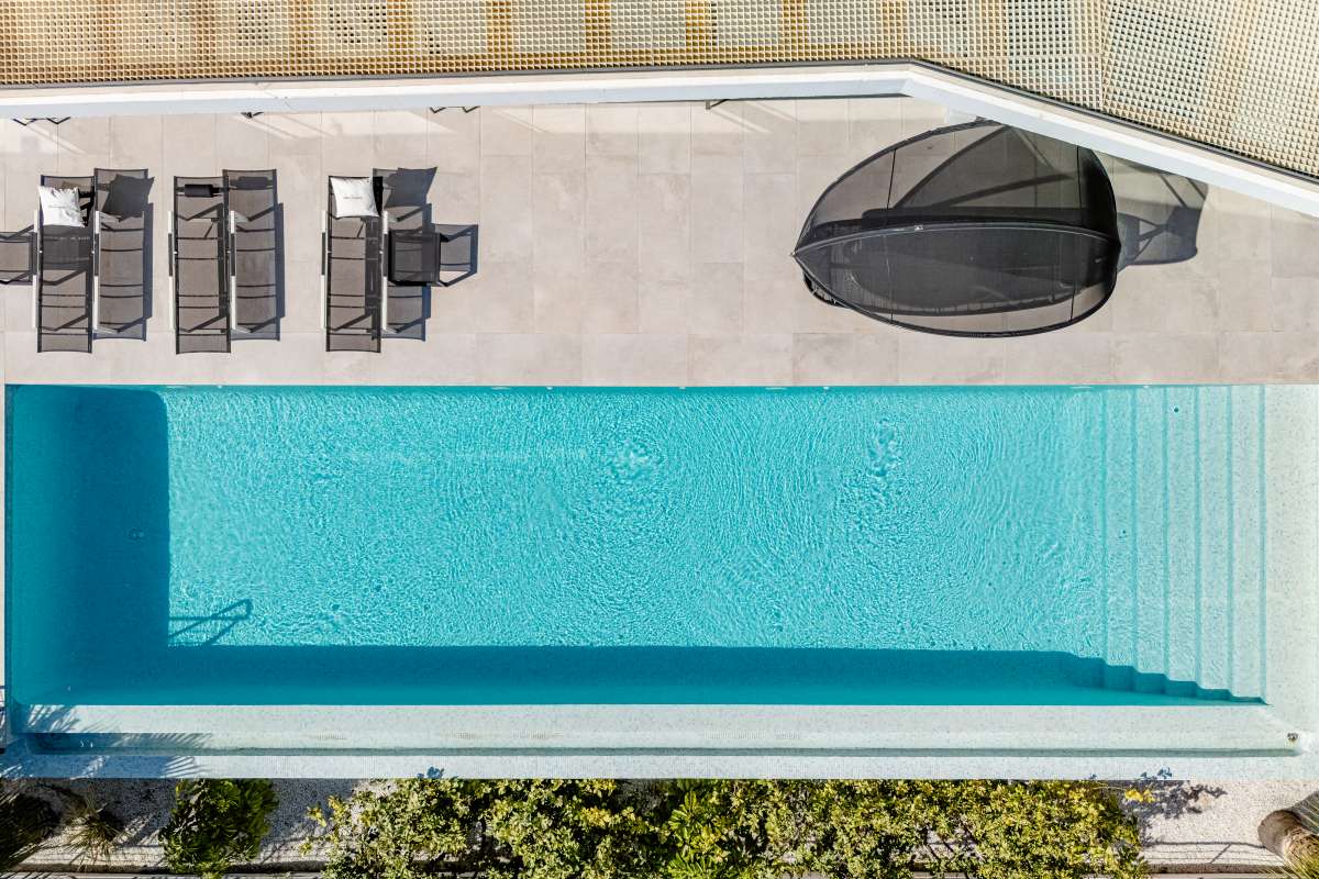 Aerial view of the infinity pool with sun loungers at a luxury modern villa in Gran Sol, Calpe.