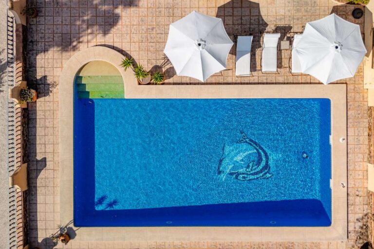 Aerial view of the private swimming pool at a historic finca in Benissa with sun loungers, parasols and terrace area