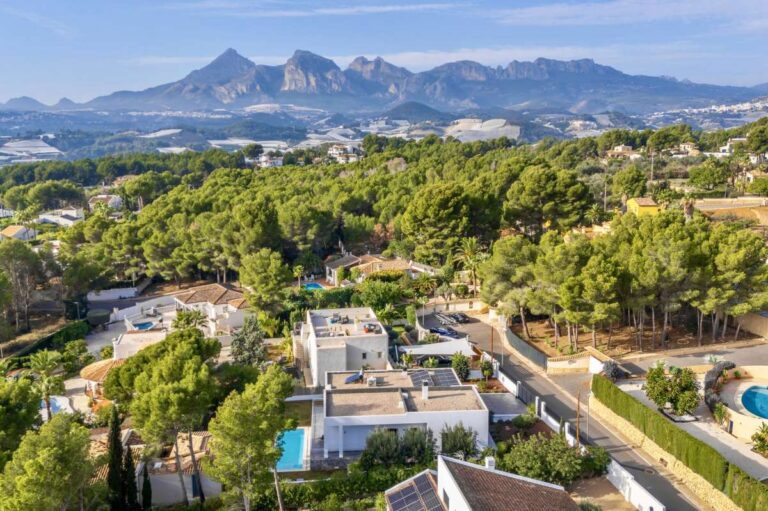 Aerial views from a single-level modern villa in Santa Clara, Altea showing surrounding homes, mountain views, greenery and residential setting
