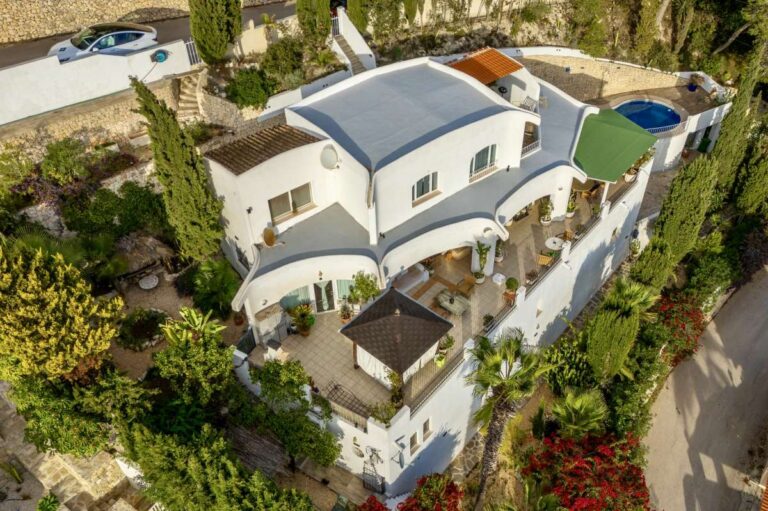 Alt text: Aerial view of a panoramic sea view villa in Benissa with private terraces, pool area, garden spaces and Mediterranean surroundings