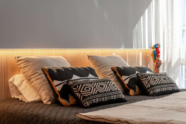 Alt text: Bedroom inside a luxury frontline beach duplex in Mascarat, Altea with soft lighting, modern bedding, cushions and bright interior finish