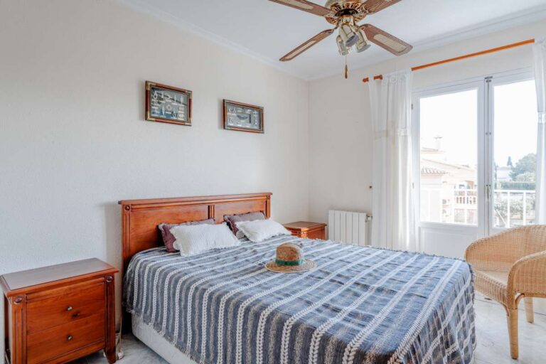 Alt text: Bedroom with traditional wooden furniture and natural light inside a Mediterranean villa with independent guest accommodation in Calpe.