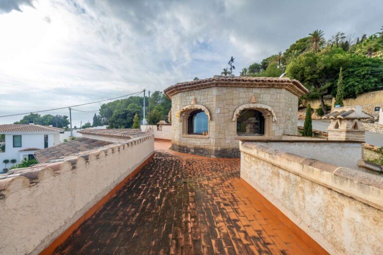 Alt text: Upper terrace at a finca-style villa in Benissa Costa with natural stone exterior, tiled flooring, sea views and Mediterranean surroundings