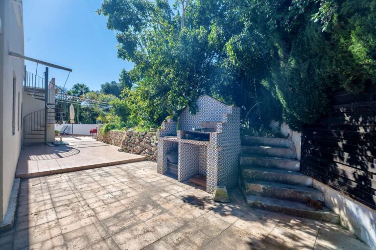 Barbecue area at a Mediterranean villa in Benissa Costa with stone terrace, garden steps and mature Mediterranean planting