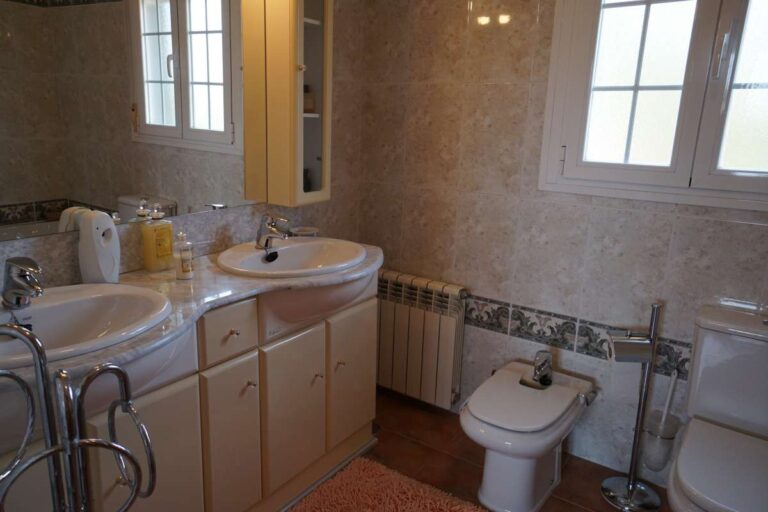 Bathroom detail with bath, bidet and natural light inside a Mediterranean villa near La Calalga Beach in Calpe.