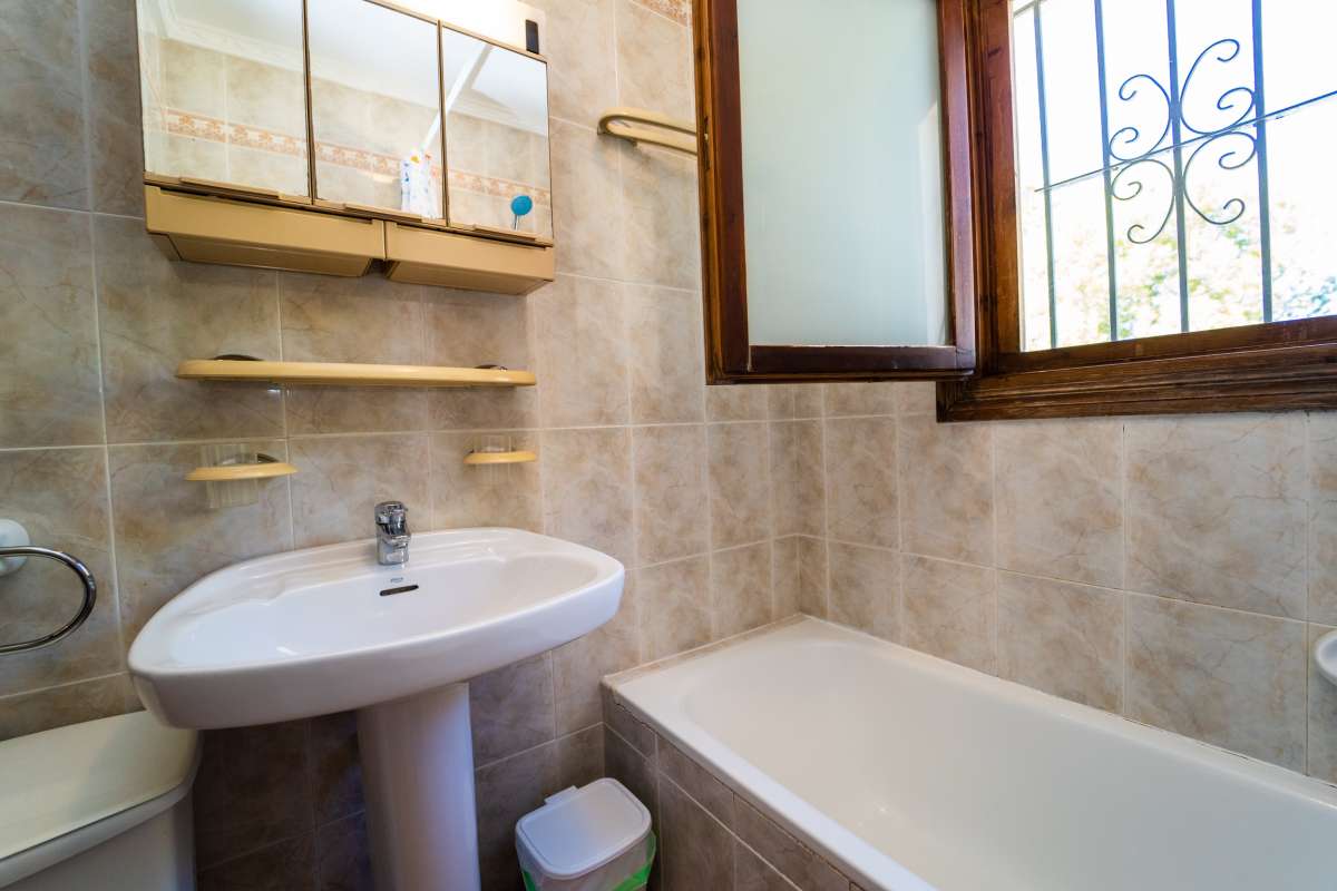 Bathroom detail with bath, sink, shelving and natural light inside a Mediterranean villa in Calpe.