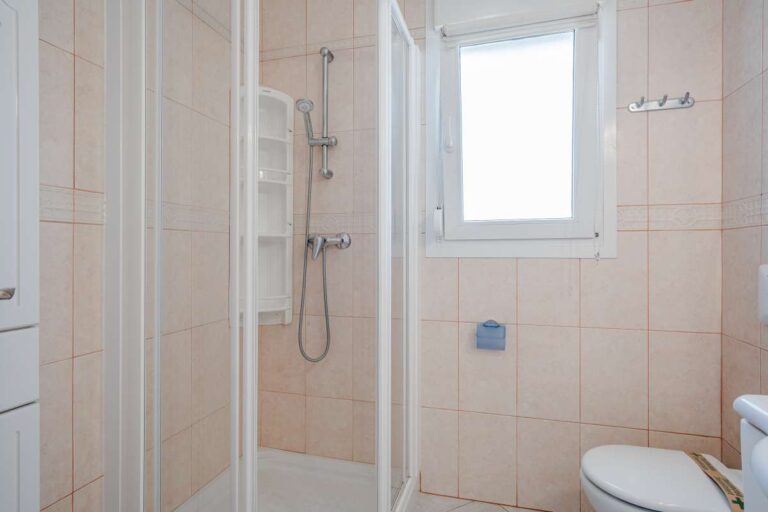 Bathroom inside a Calpe villa with shower enclosure, toilet and window