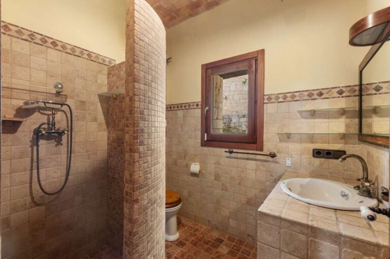 Bathroom inside a finca-style villa in Benissa Costa with bath, shower area, vanity unit, tiled walls and rustic Mediterranean finish