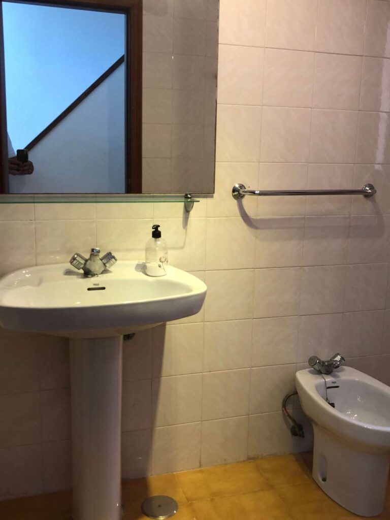 Bathroom inside a frontline townhouse in Calpe with sink, bidet and tiled walls