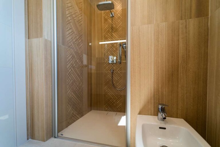 Badezimmer in einer neu gebauten Luxusvilla in der Nähe des Yachthafens Puerto Blanco in Calpe mit ebenerdiger Dusche in Holzoptik, Waschtischbereich und moderner Ausstattung