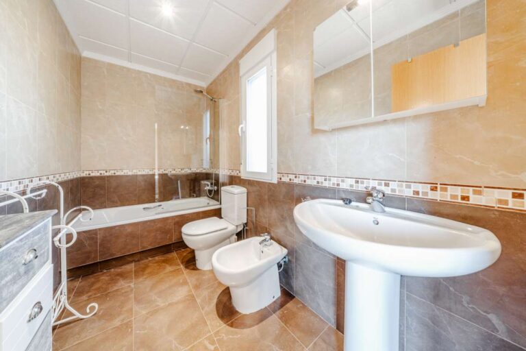 Bathroom inside a semi-detached house in Calpe with bathtub, sink, bidet, toilet and natural light