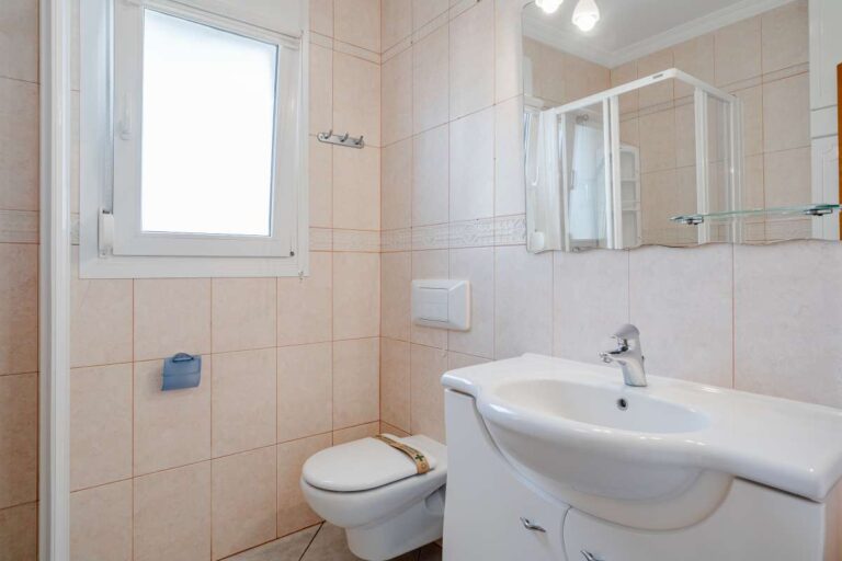Bathroom inside a villa in Calpe with sink, toilet, mirror and natural light
