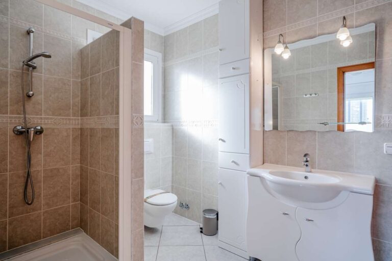 Bathroom inside a villa in Calpe with walk-in shower, sink, mirror and natural light