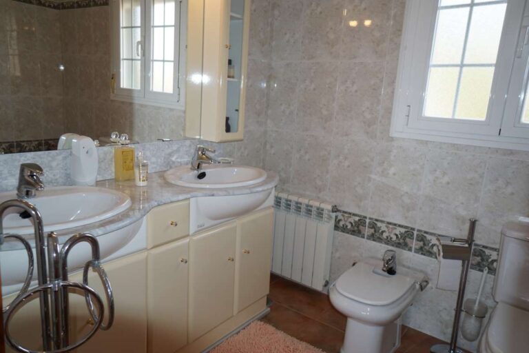 Bathroom with bath, sink and natural light inside a Mediterranean villa in Calpe.