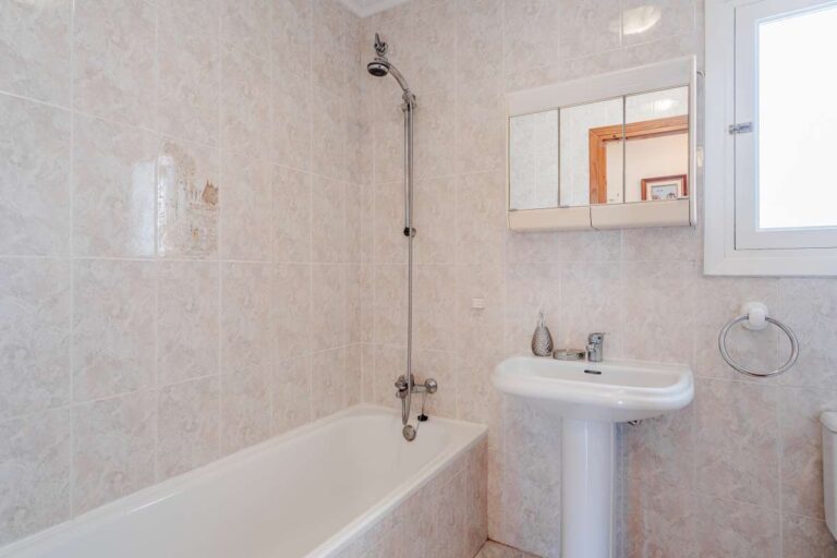 Bathroom with bath, sink and natural light inside a Mediterranean villa with independent guest accommodation in Calpe.