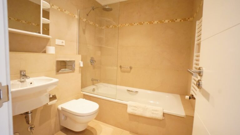 Bathroom with bath, vanity, and fitted fixtures inside a villa in La Fustera near the sea.