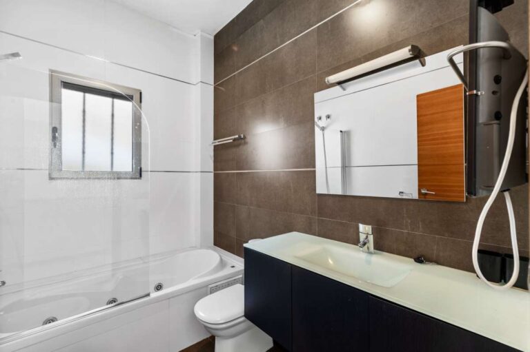 Bathroom with bath, vanity and shower fitting inside a modern spacious villa in Calpe.