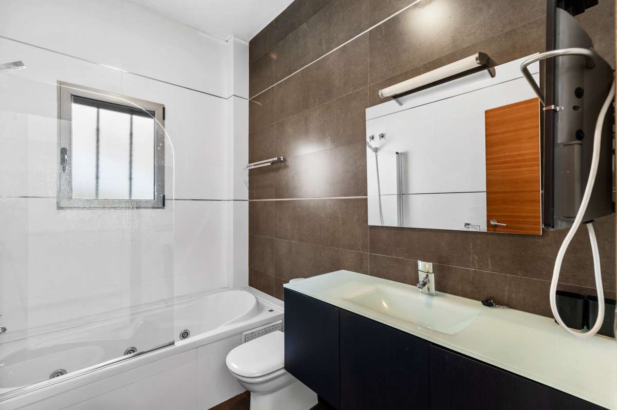 Bathroom with bath, vanity and shower fitting inside a modern spacious villa in Calpe.