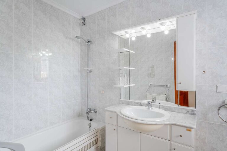 Bathroom with bath, vanity and tiled walls inside a Mediterranean villa with independent guest accommodation in Calpe.