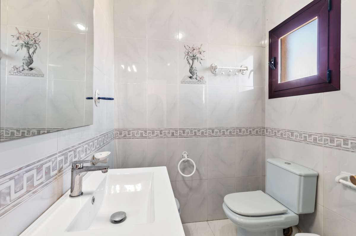 Bathroom with bathtub, toilet and natural light inside a guest apartment at a spacious villa in Calpe.