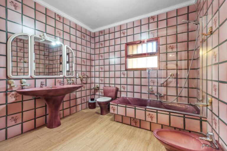 Bathroom with bathtub, vanity, mirror and tiled finishes inside a spacious villa in Calpe.
