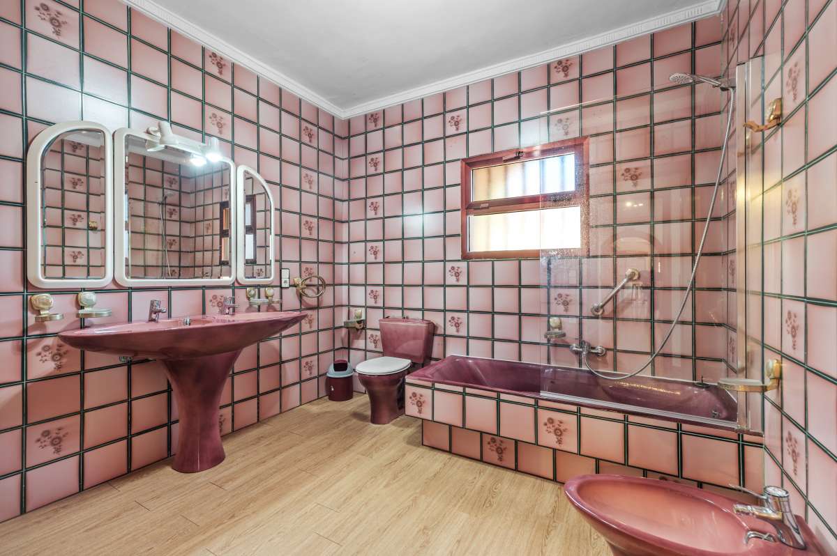 Bathroom with bathtub, vanity, mirror and tiled finishes inside a spacious villa in Calpe.