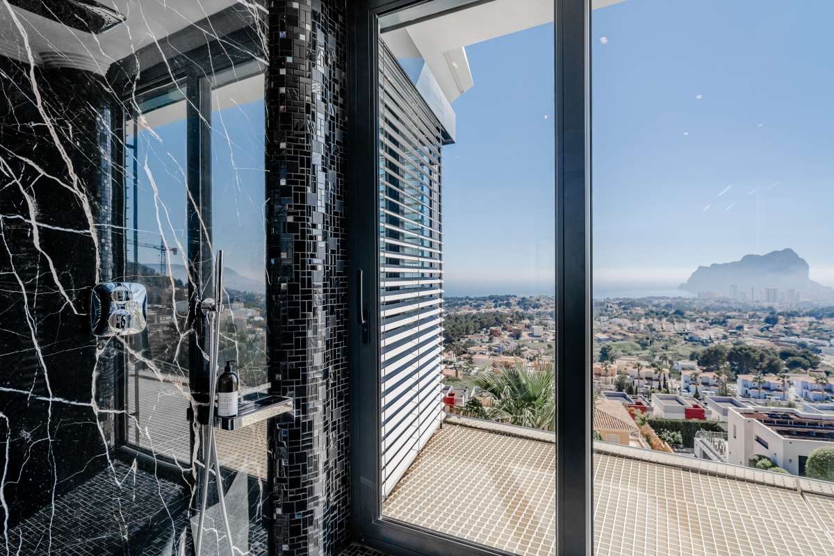 Bathroom with black marble-style finishes, shower and sea views inside a luxury villa in Gran Sol, Calpe.