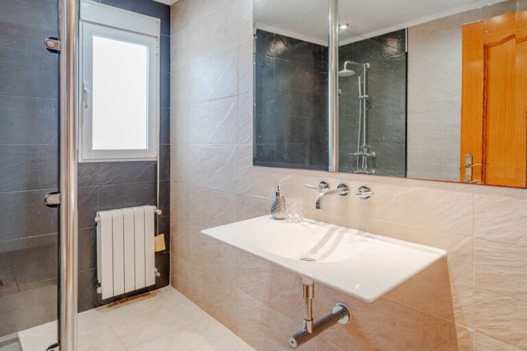Bathroom with double vanity, shower area and natural light inside a Mediterranean villa in Calpe.