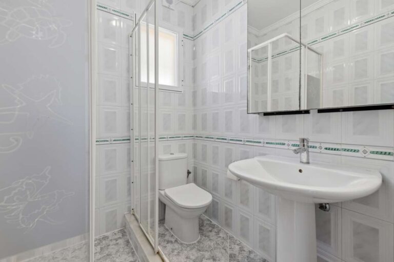 Bathroom with shower, sink, toilet, and tiled walls inside a villa in Calpe.